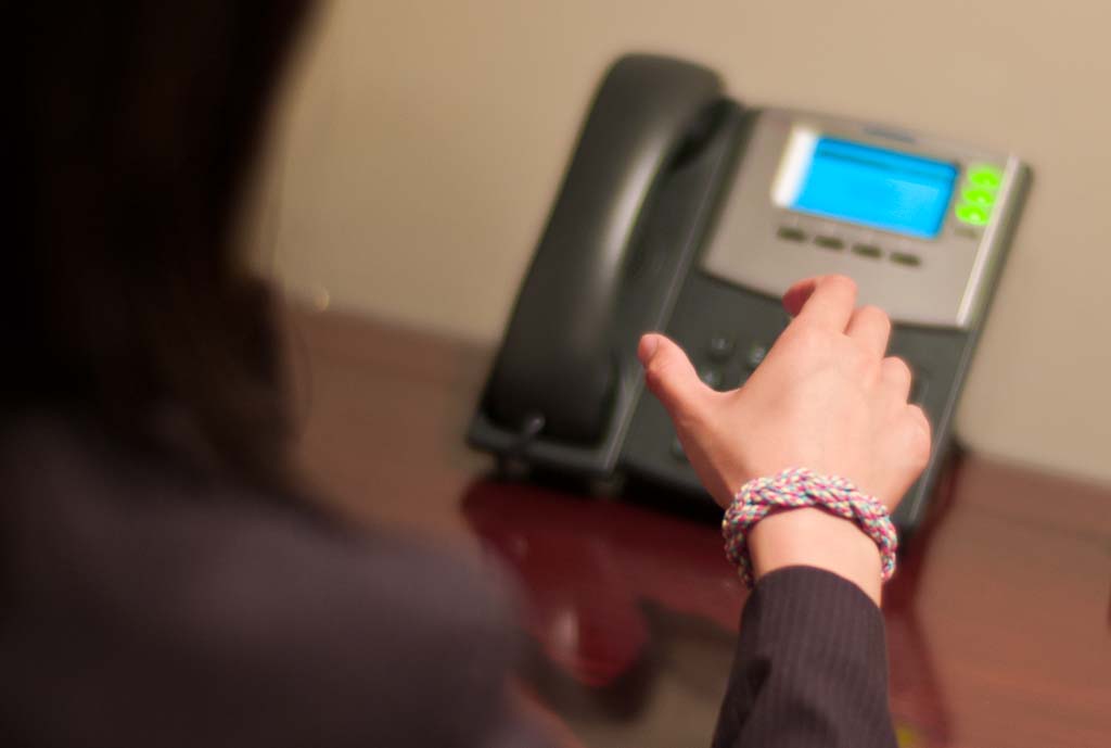 Image Of Person Wearing Friendship Bracelet About To Answer Phone