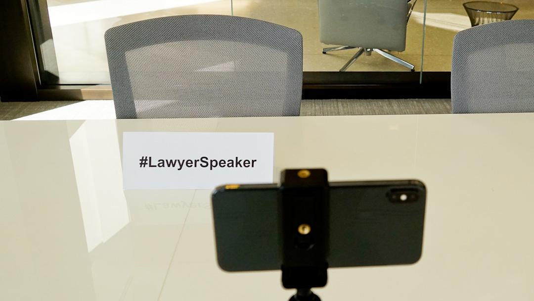 Image Of Sign Stating #LawyerSpeaker And A Smartphone Set Up To Record A Video